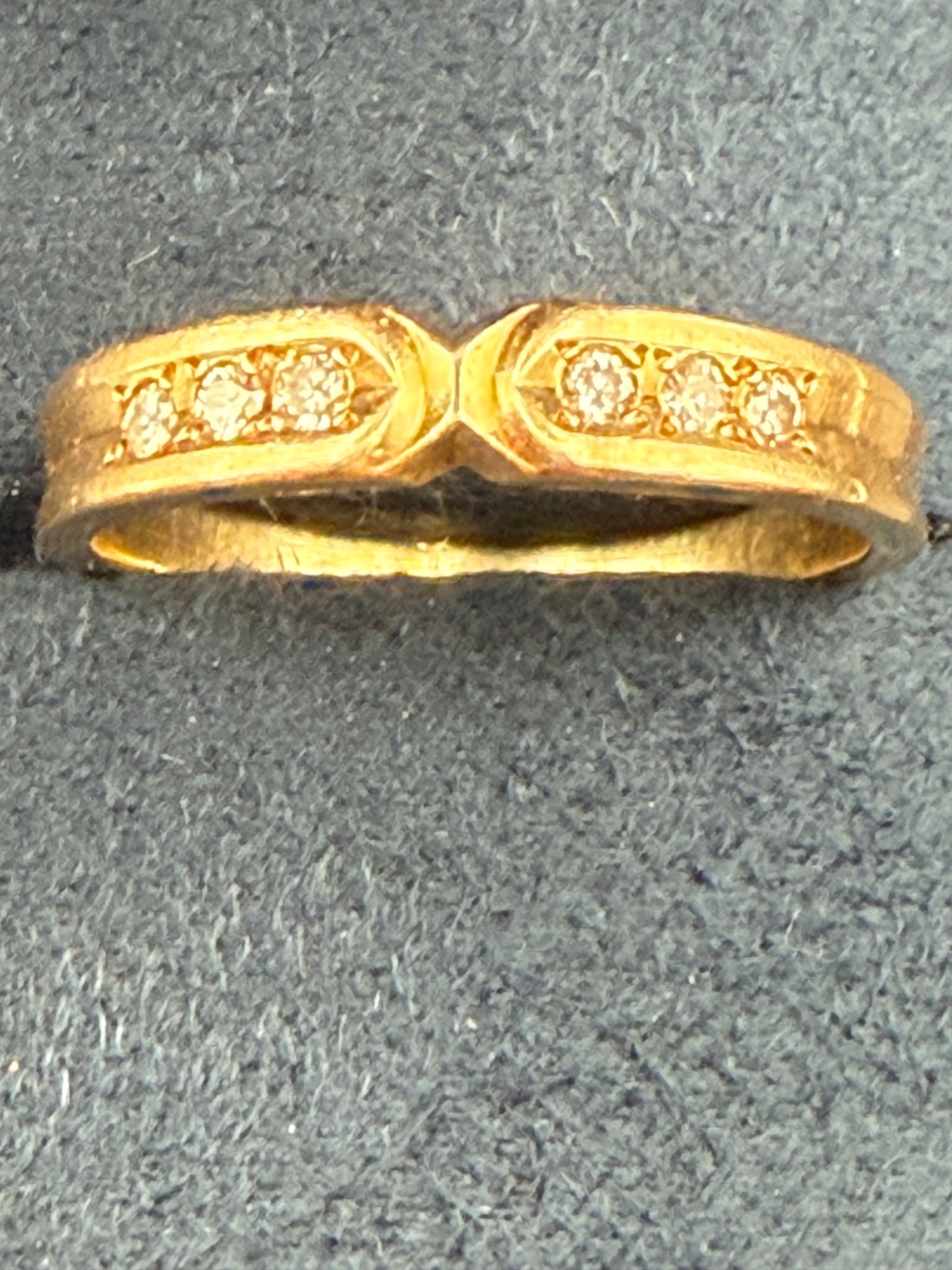 Closeup 14K yellow gold ring featuring a vivid emerald-cut blue topaz and four accent diamonds