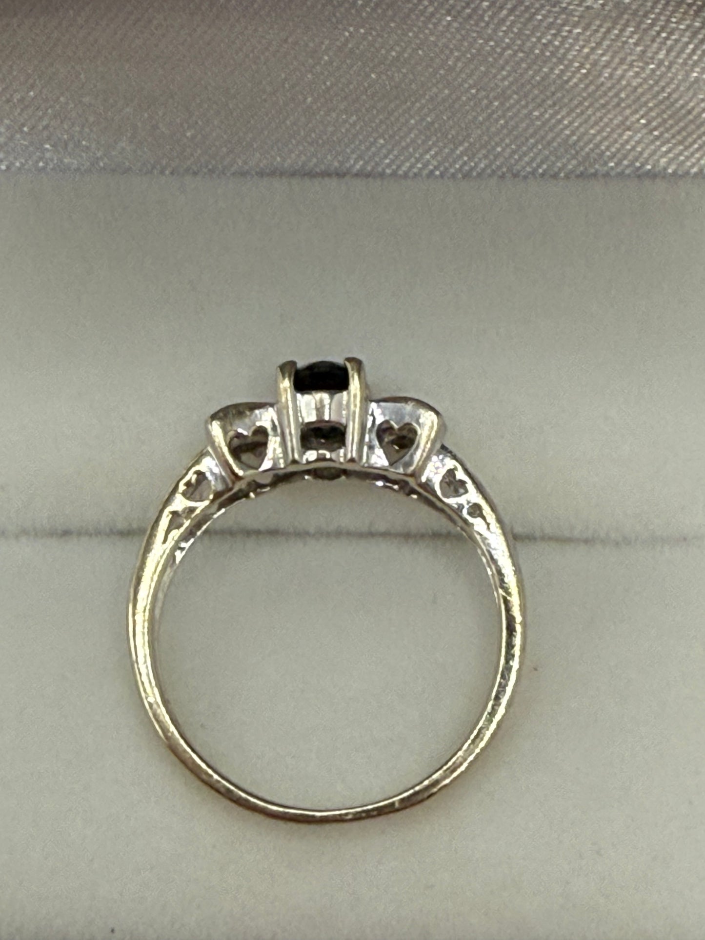 Side profile showing sapphire setting and diamond-accented bow design.