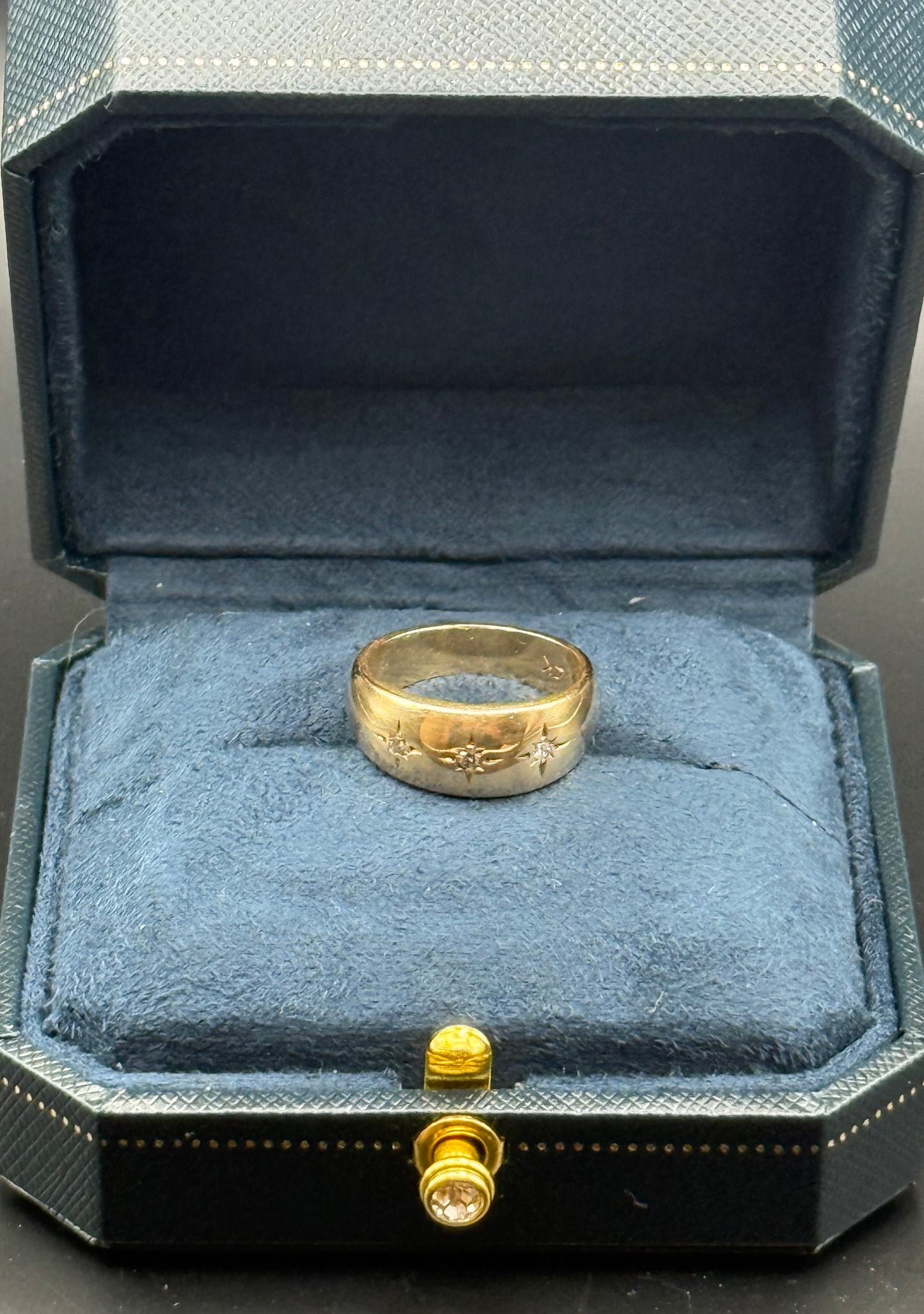 Side view of engraved starburst diamond details on gold band