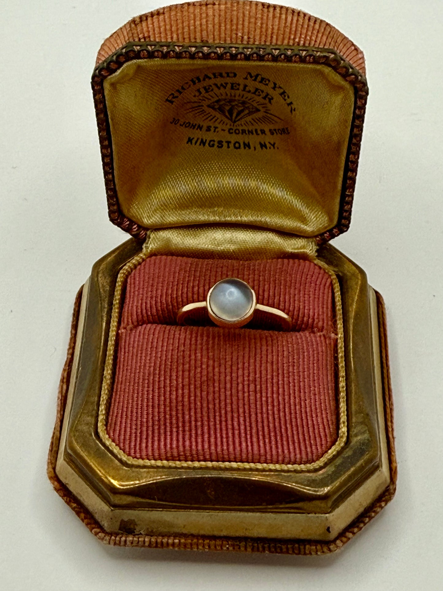 Victorian moonstone ring in antique jeweler’s box from Kingston, NY, showing soft blue glow in domed cabochon.