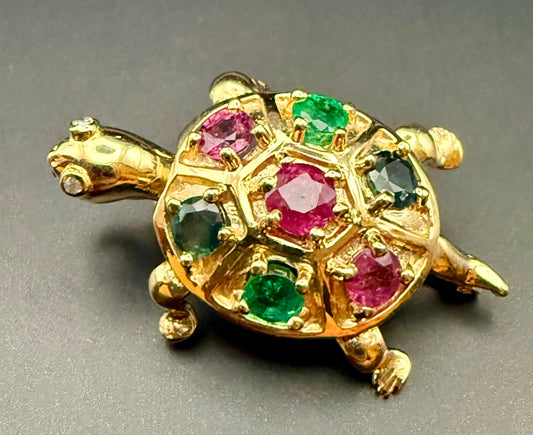Vintage European 14K turtle brooch with gemstone shell on dark background