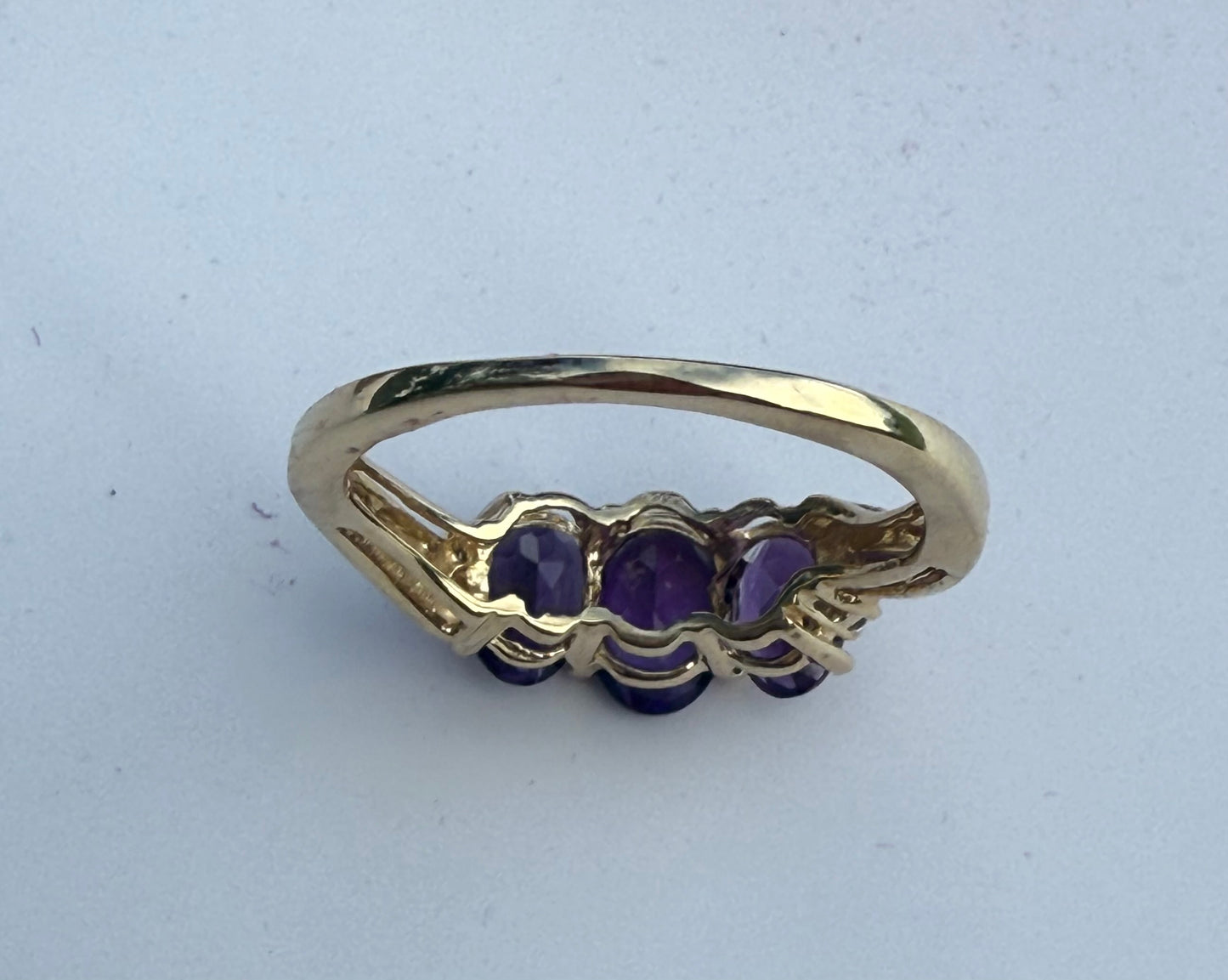 Back View of Vintage 3-stone amethyst ring in yellow gold with oval purple gemstones, trilogy design symbolizing past, present, and future.
