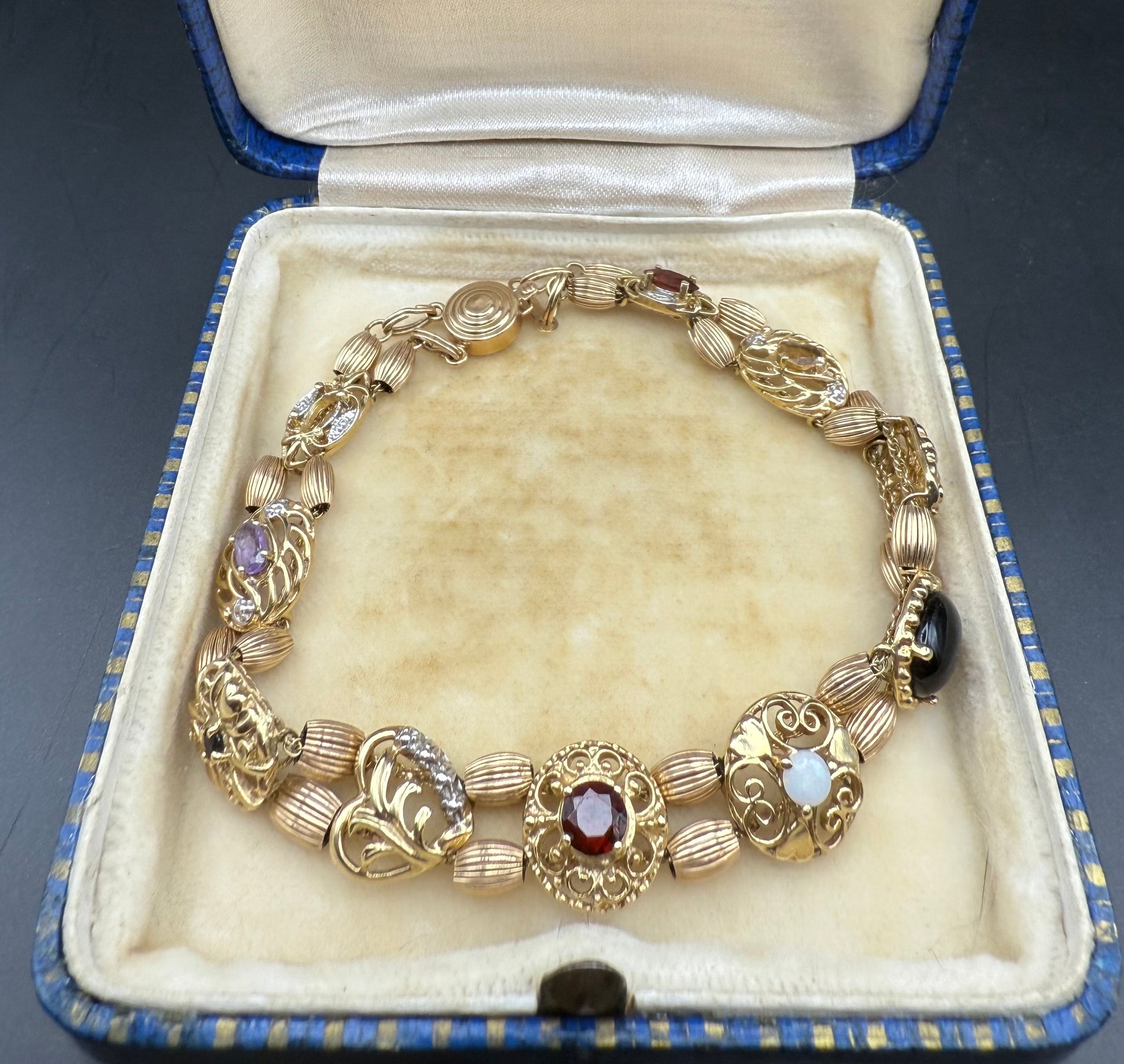 10K gold multi-gemstone slide charm bracelet displayed open in vintage box