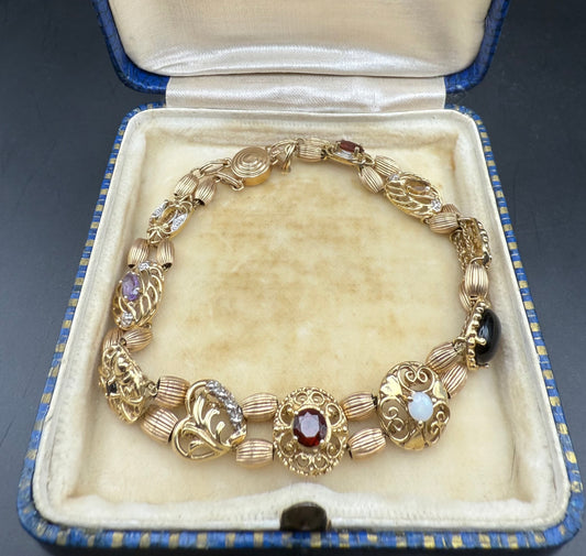 10K gold multi-gemstone slide charm bracelet displayed open in vintage box