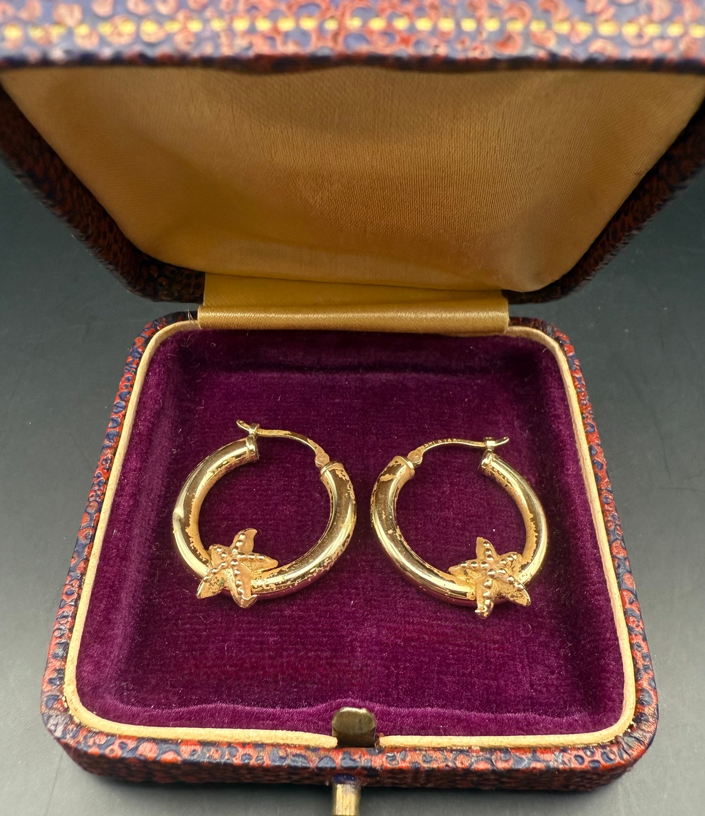 14K gold hoop earrings with starfish displayed in vintage velvet jewelry box