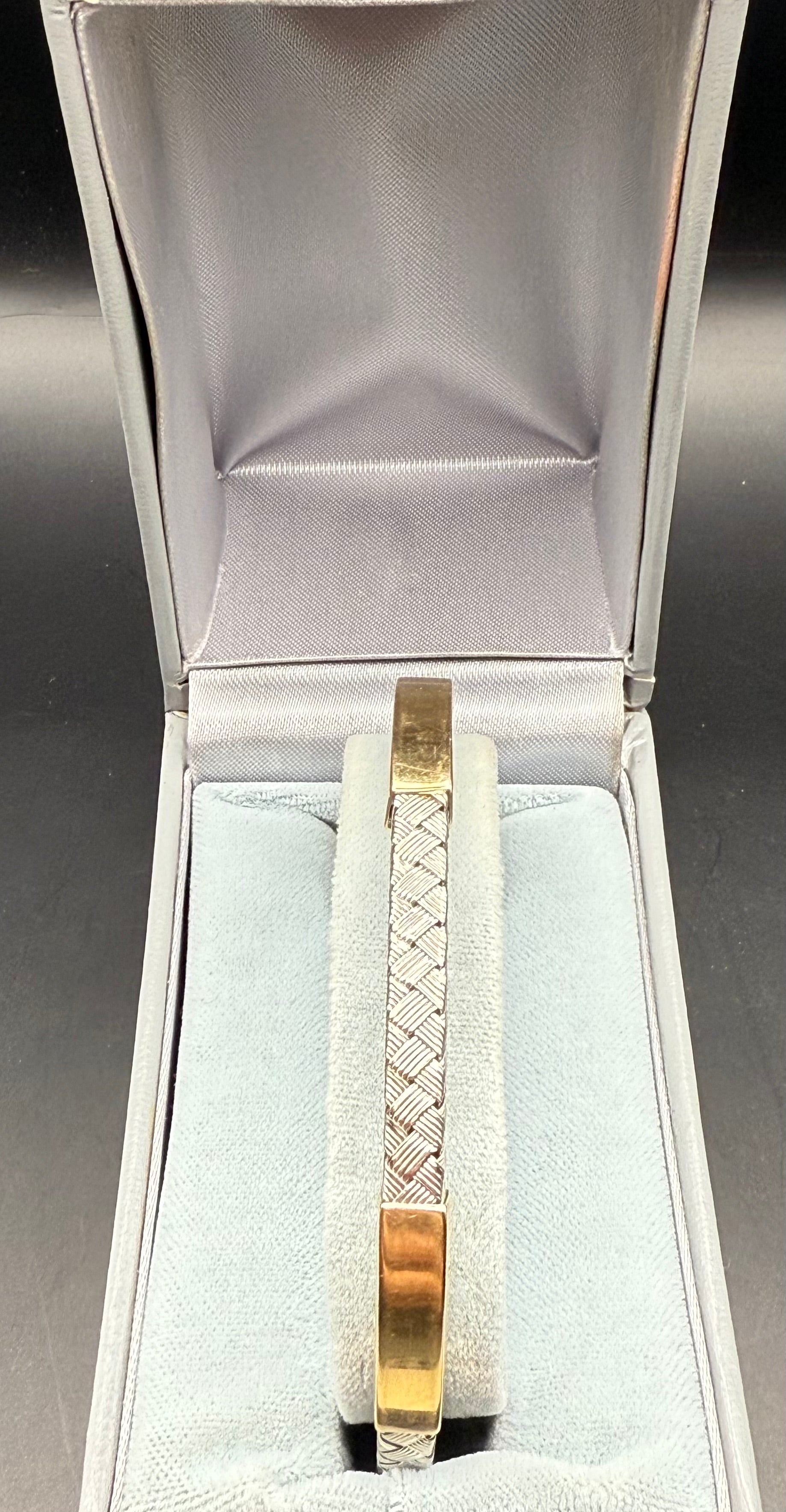 14K white and yellow gold braided bracelet displayed in velvet box