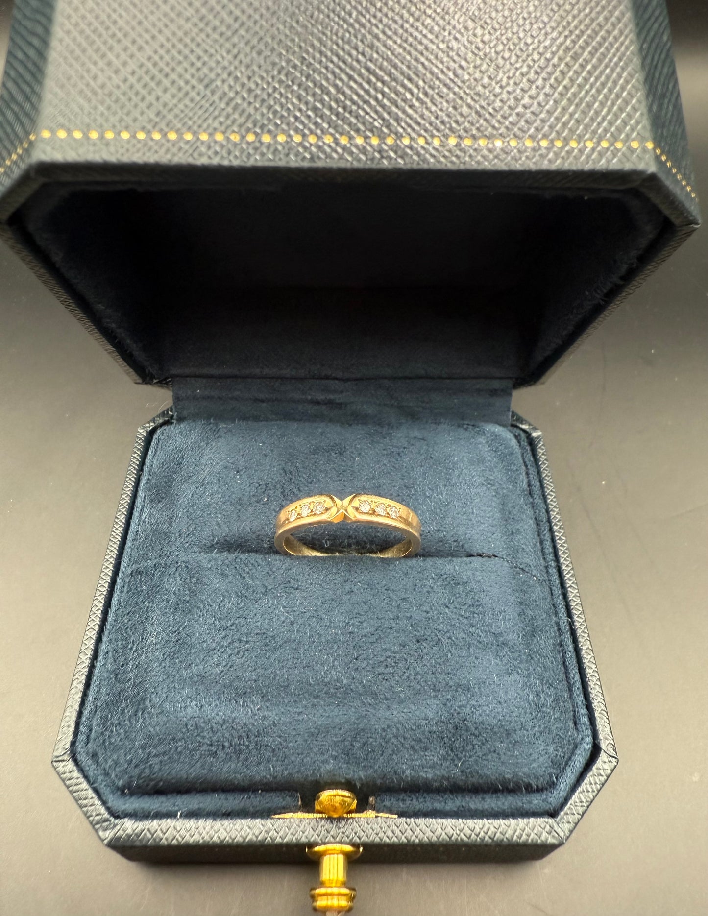 14K yellow gold ring featuring a vivid emerald-cut blue topaz and four accent diamonds, displayed in a vintage jewelry box