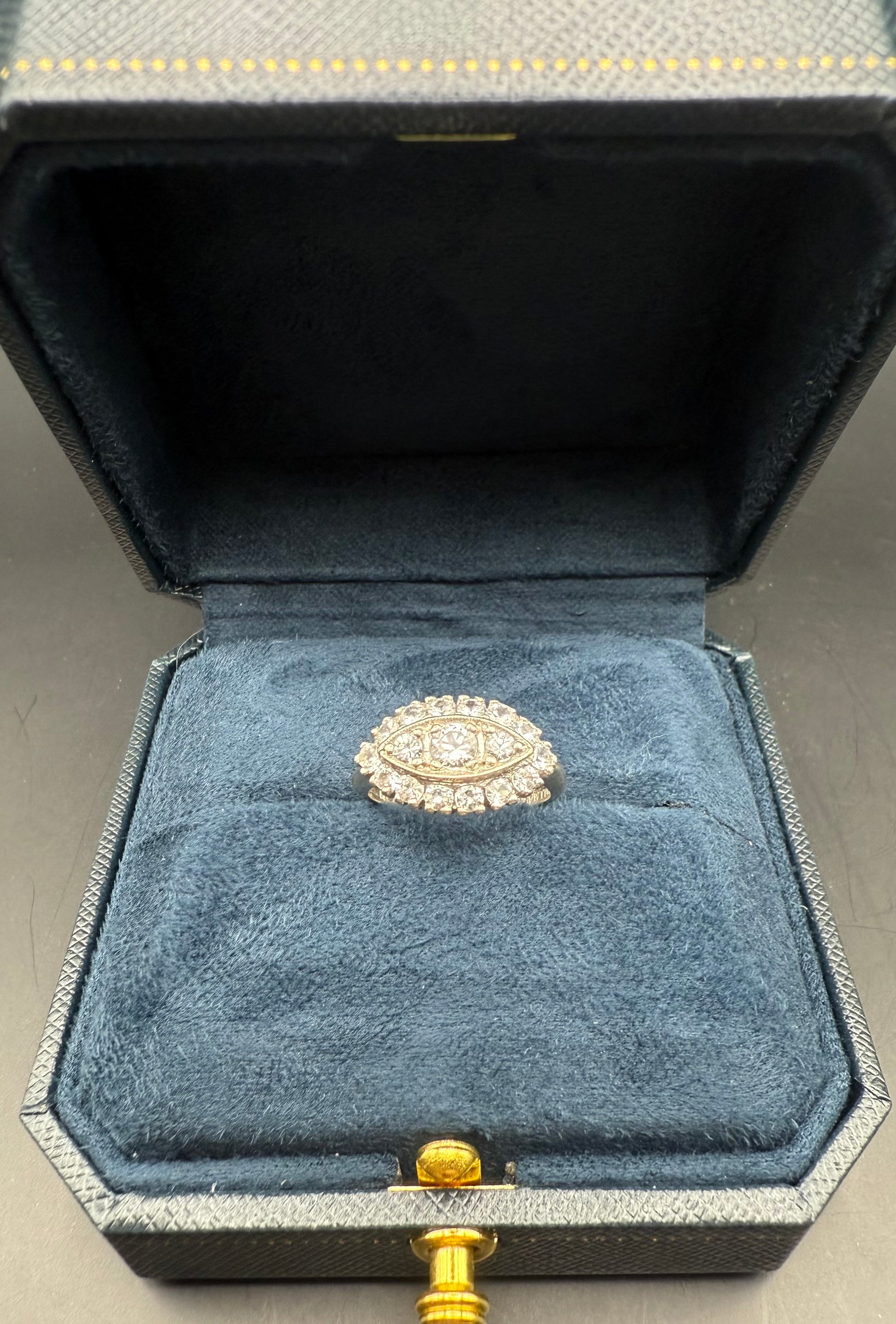 1950s 14K white gold diamond halo ring in navy jewelry box with marquise-shaped cluster setting.