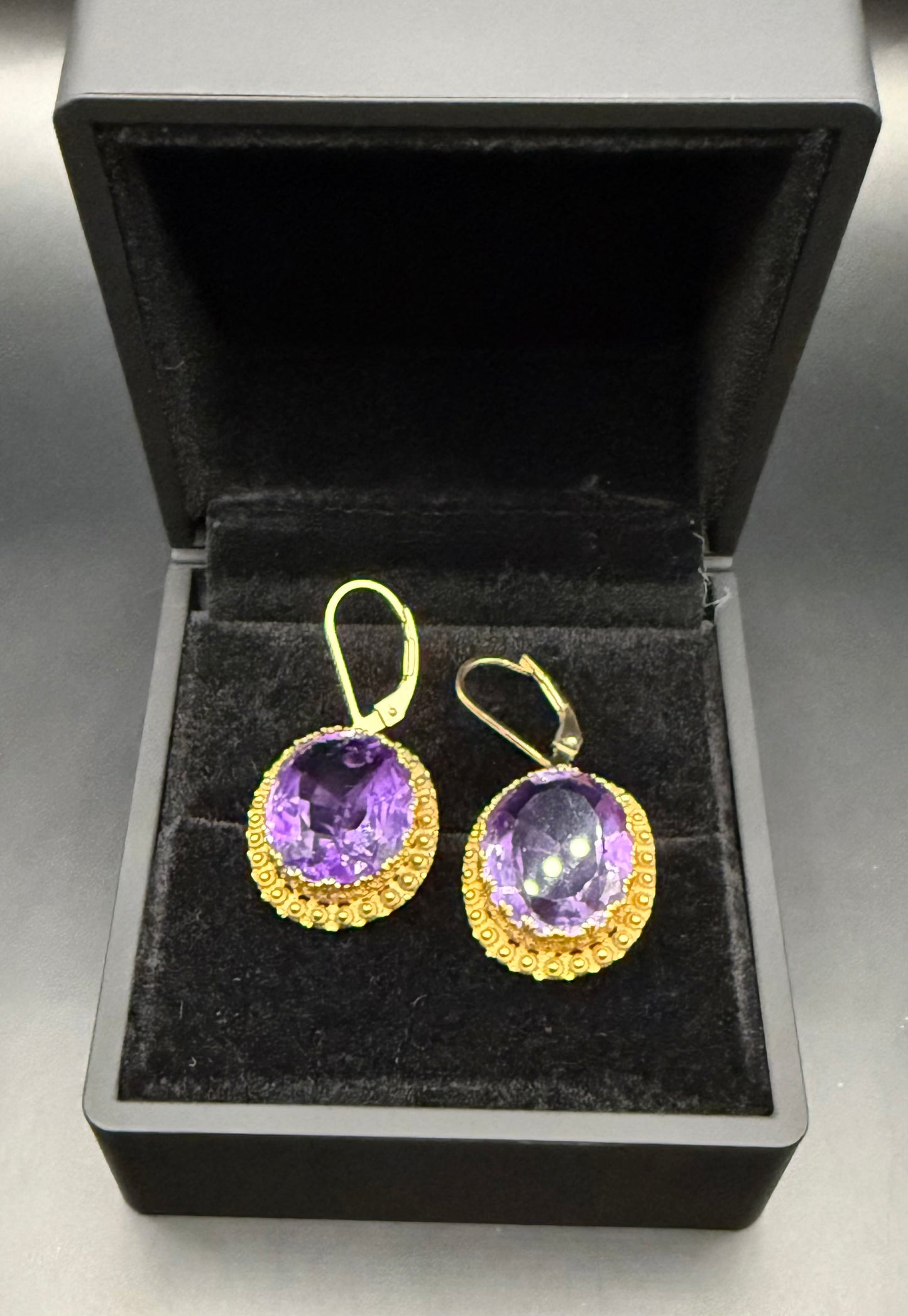 Alternate angle of antique amethyst earrings in black velvet box