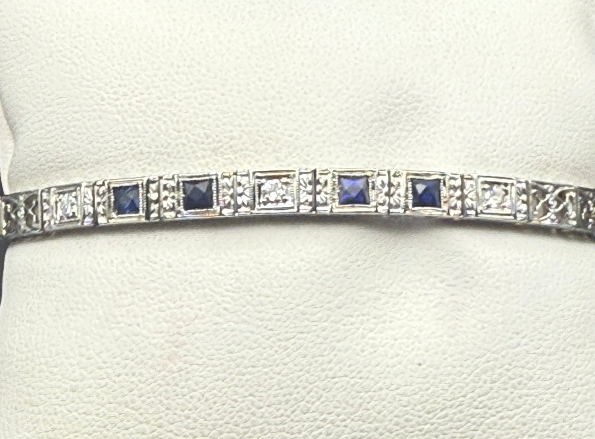 Angled close-up of Art Deco bracelet highlighting old European cut diamonds and sapphire squares