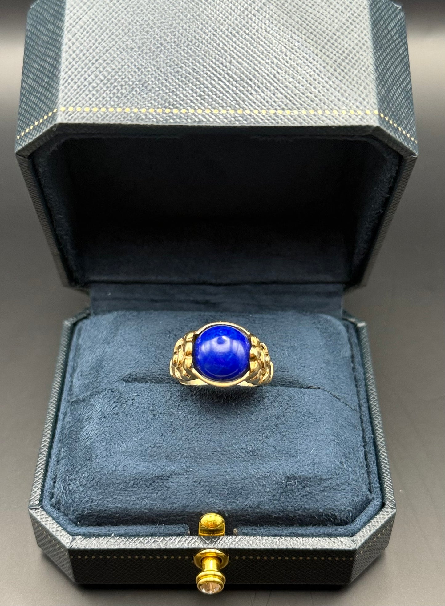 Antique 10K gold Arts and Crafts ring with deep blue lapis cabochon in navy jewelry box.