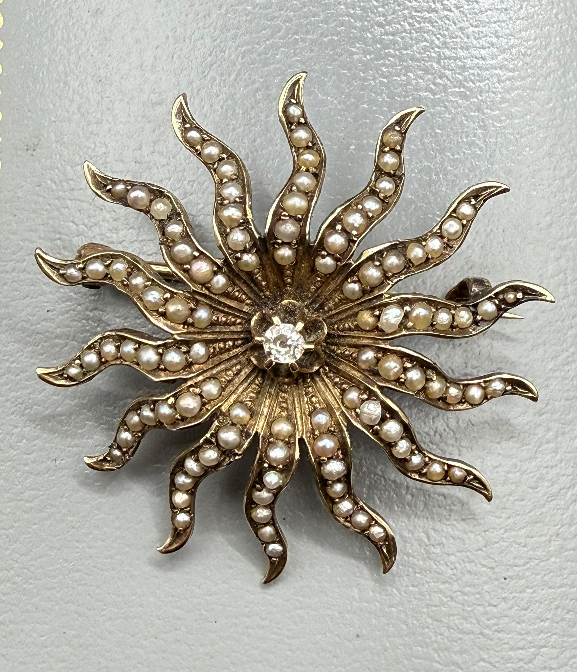 Antique 10K gold starburst brooch with seed pearls and diamond center