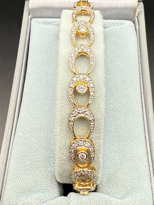 Tennis bracelet displayed in presentation box, oval diamond-set links visible