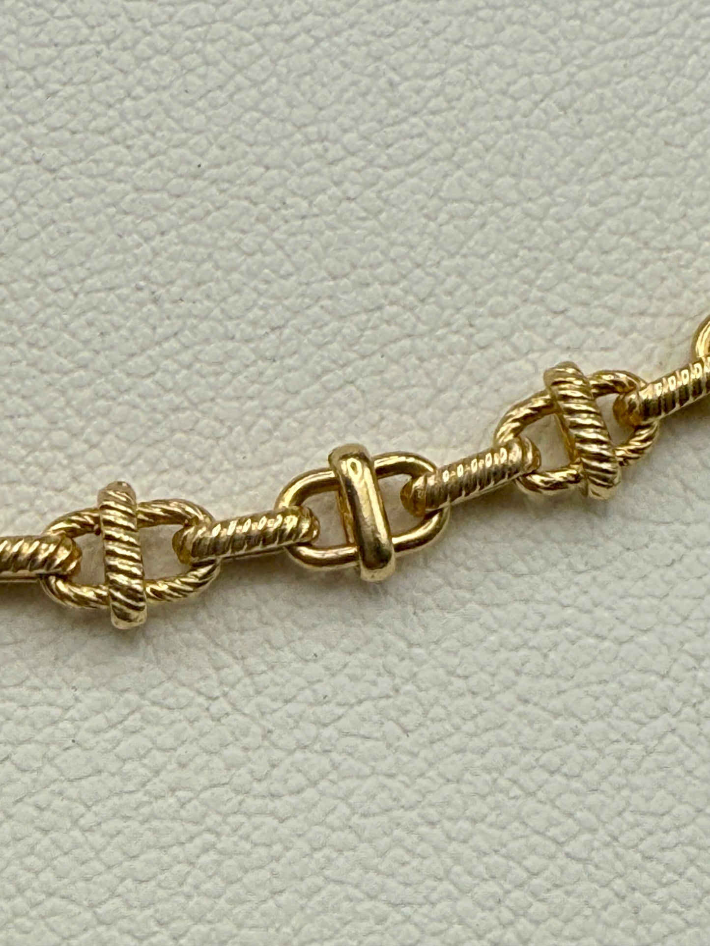 Close-up of 14K gold intricate link chain showing textured and polished detail