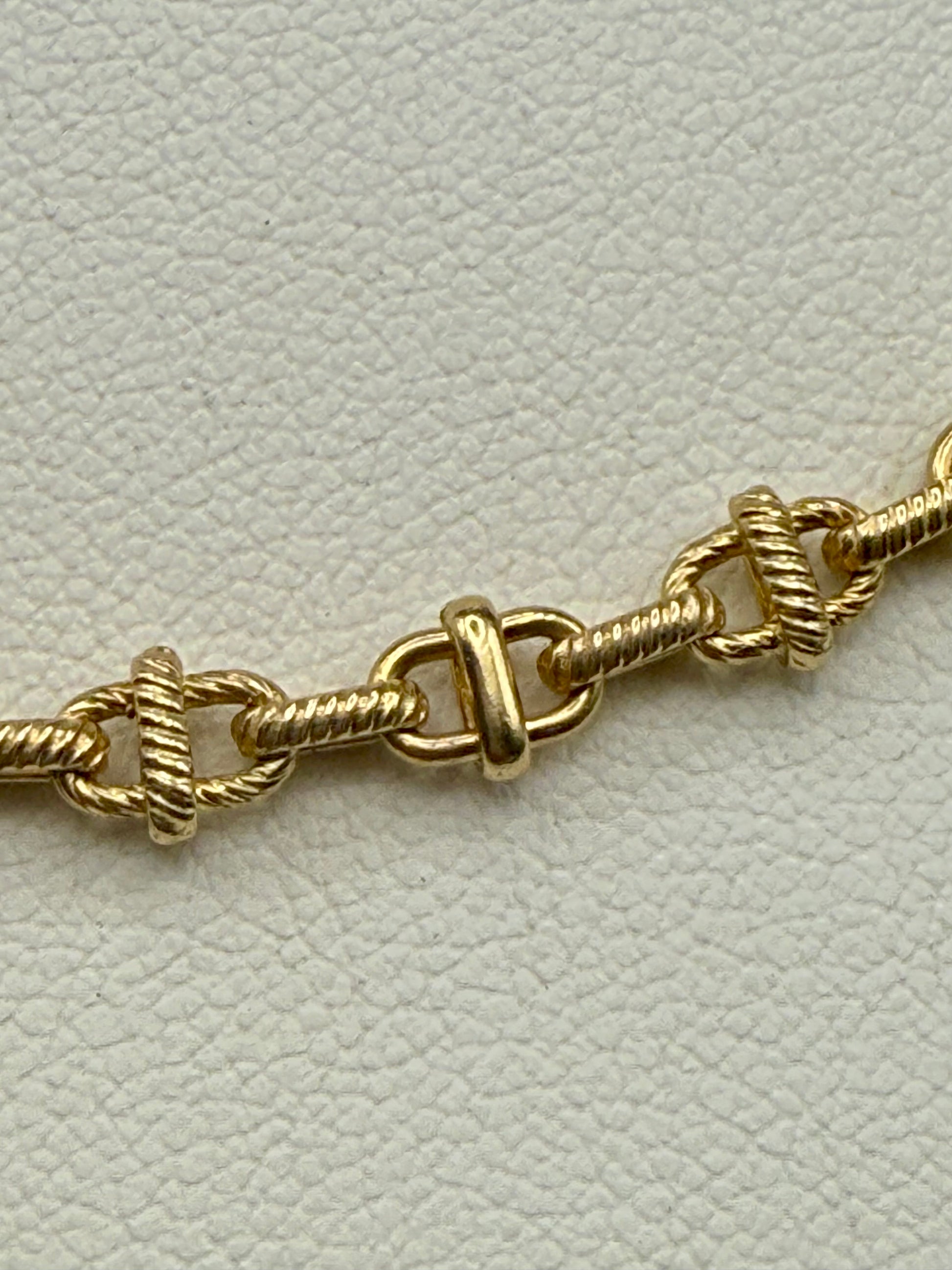 Close-up of 14K gold intricate link chain showing textured and polished detail