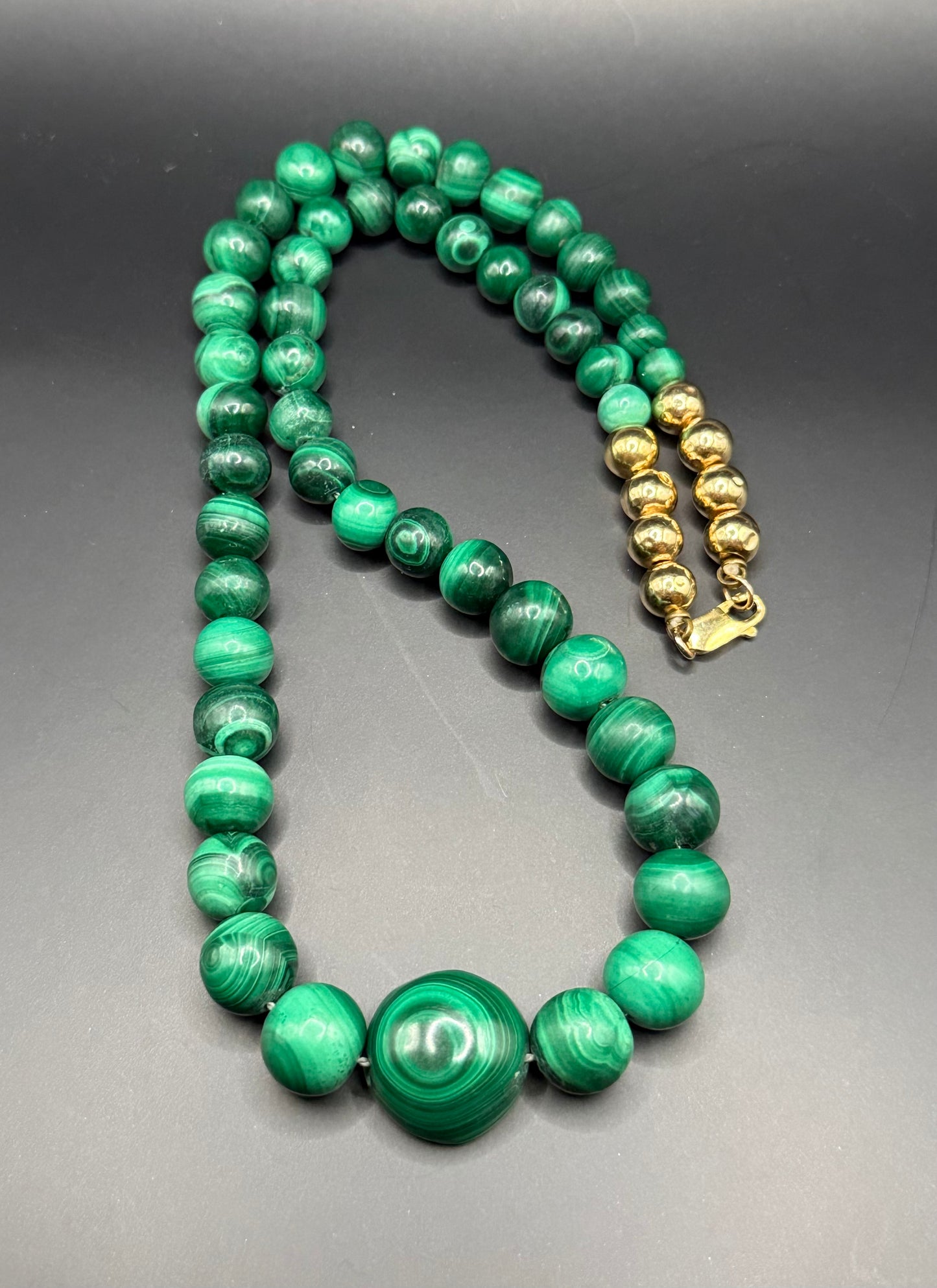 Close-up of 14k gold clasp and gold accent beads on malachite necklace