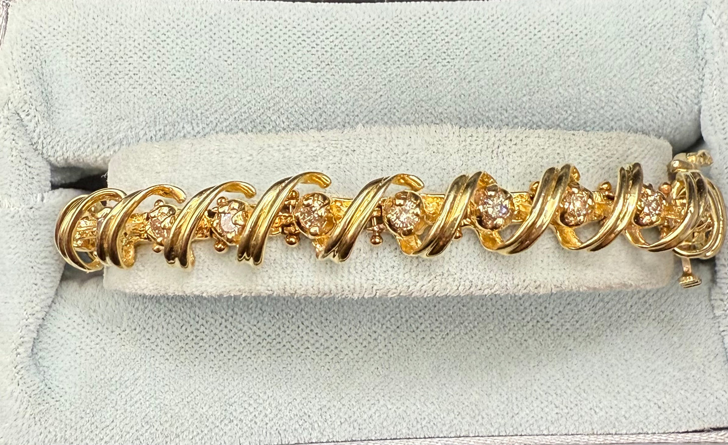 Close-up of scroll loop links wrapping round diamonds along bracelet
