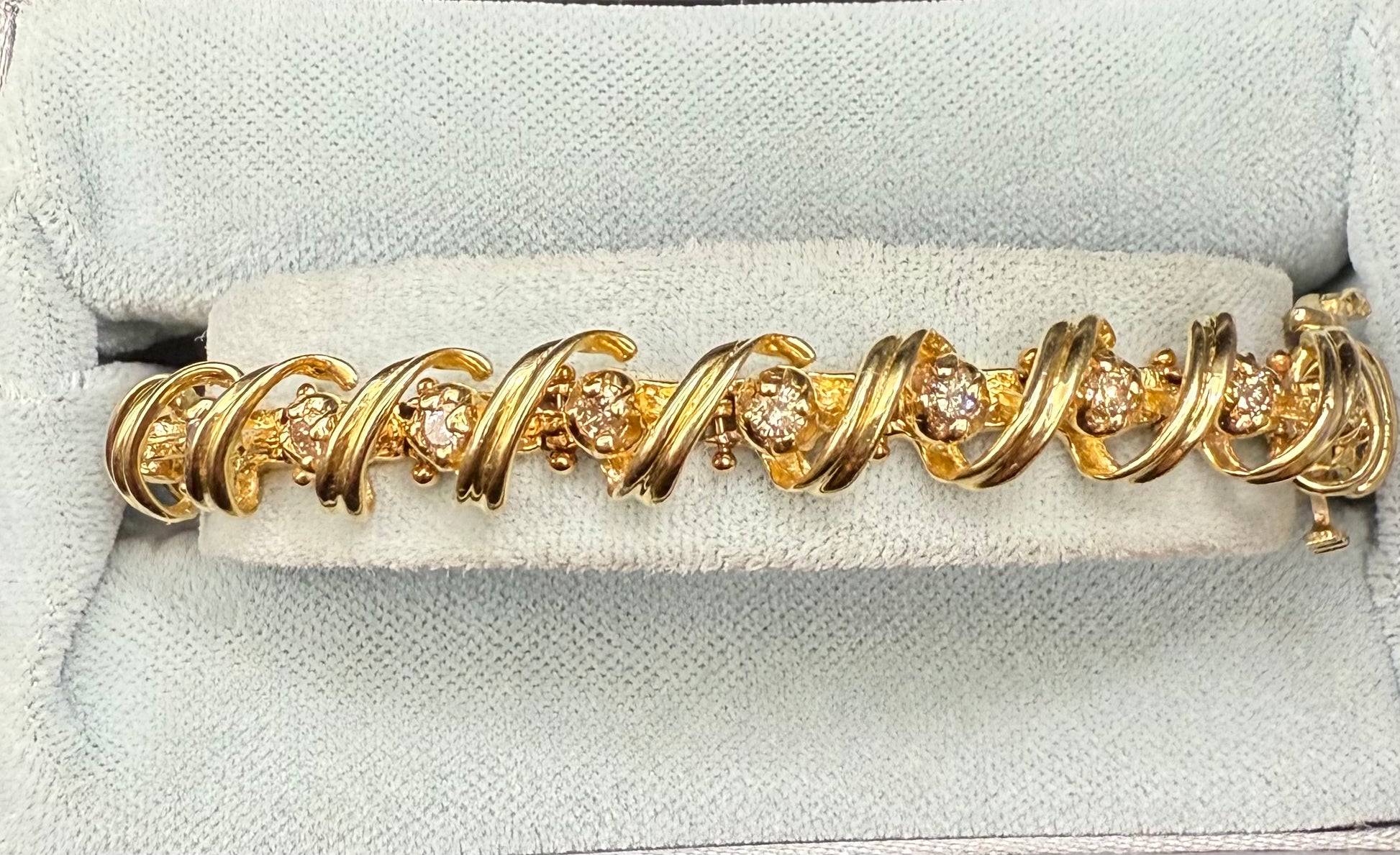 Close-up of scroll loop links wrapping round diamonds along bracelet
