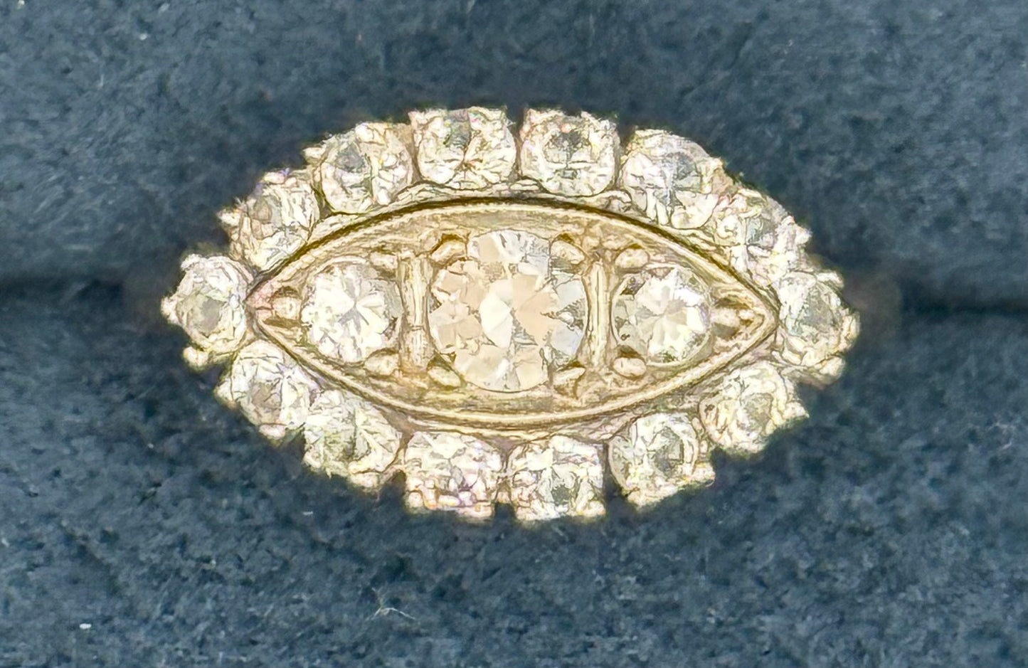 Close-up of vintage 14K white gold ring with 17 round brilliant diamonds in marquise-shaped halo.