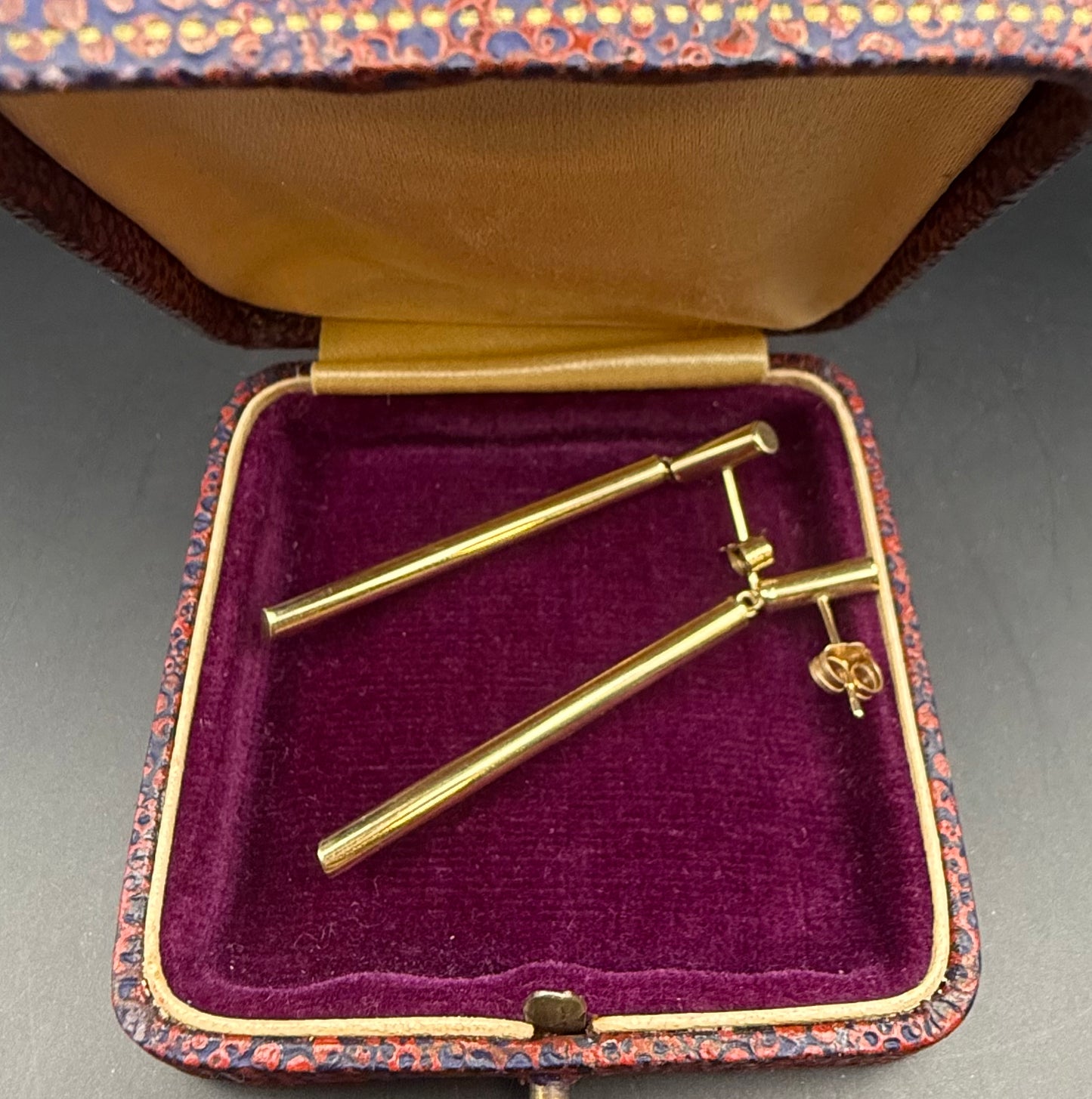 Earrings displayed in vintage velvet jewelry box