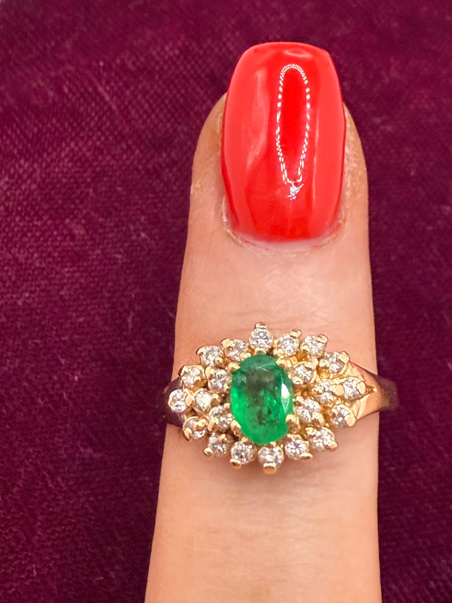 Emerald and diamond ring modeled on finger, vintage cluster design