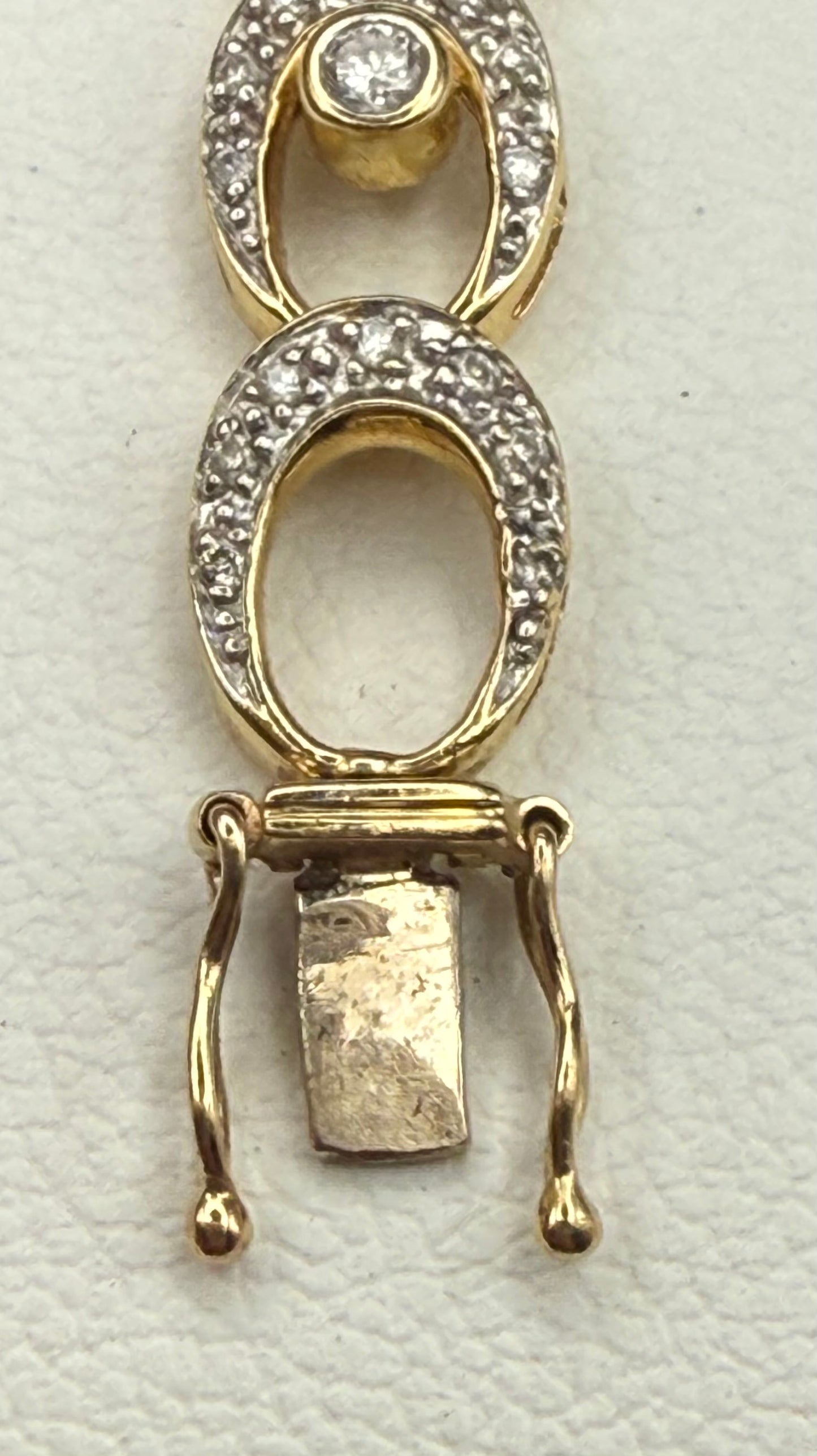 End of bracelet showing secure double safety clasp in gold