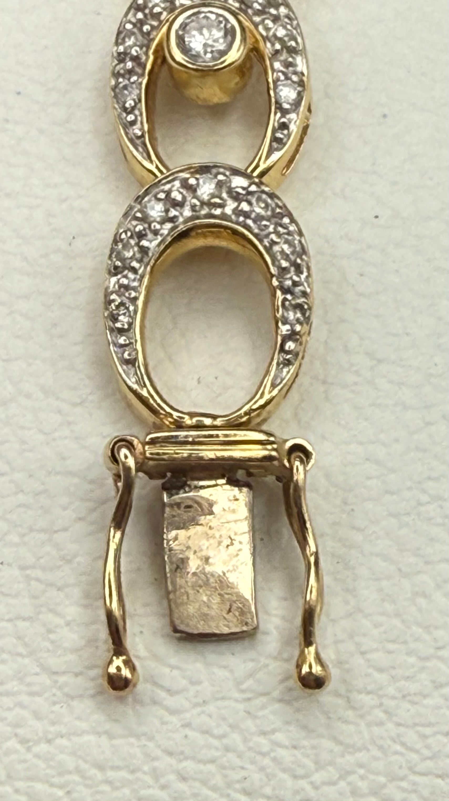 End of bracelet showing secure double safety clasp in gold