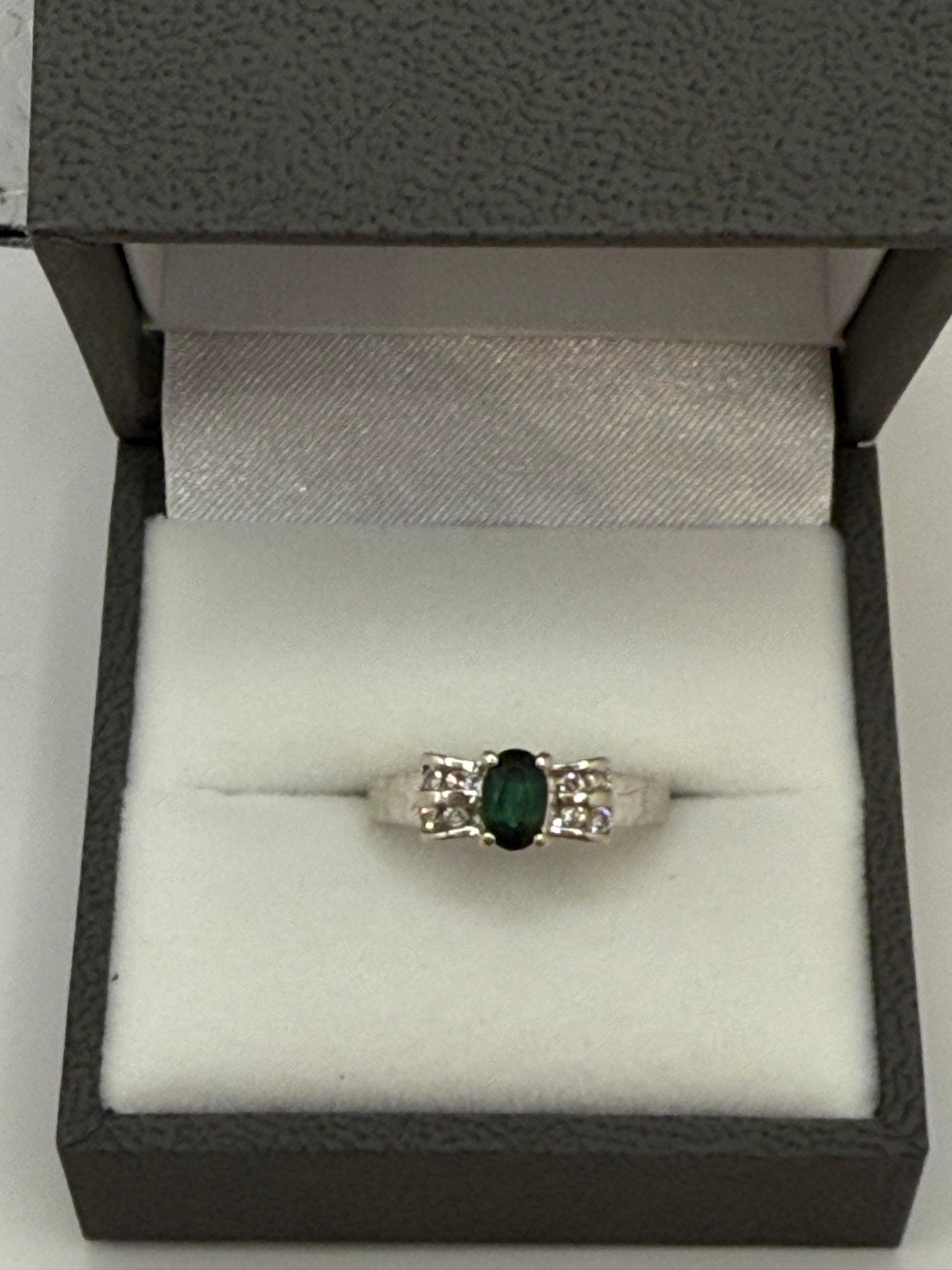 Front view of vintage 14K white gold sapphire and diamond bow ring in gray jewelry box.