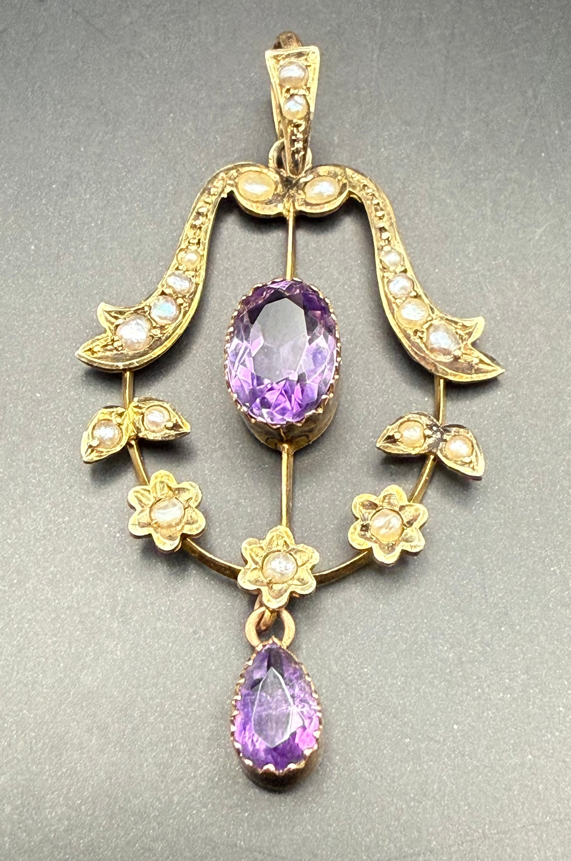 Close-up of amethyst and seed pearl detailing in gold bow design