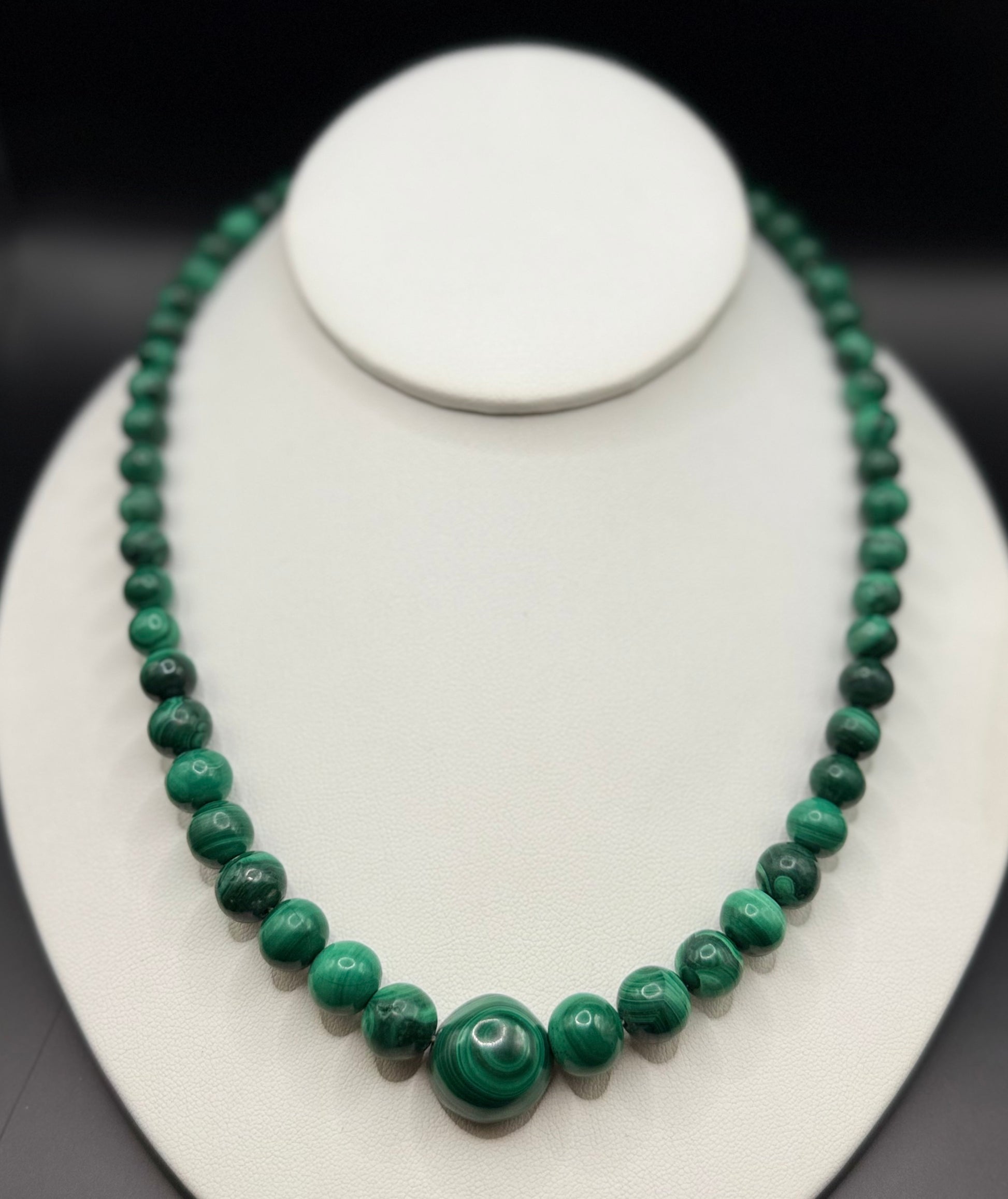 Modern estate 14k gold graduated malachite bead necklace displayed on stand
