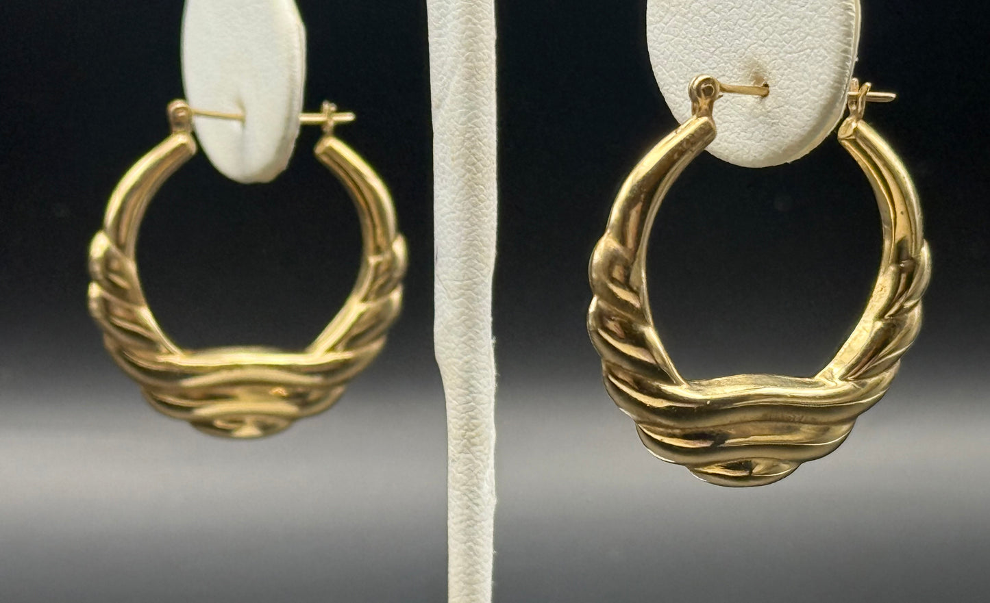 Pair of vintage 14K yellow gold hoop earrings on display stand, statement style