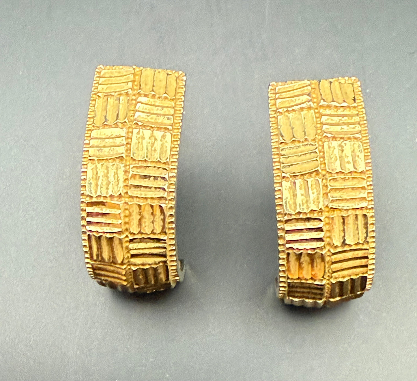 Close-up of vintage ZRW 14k gold textured half hoop earrings showing geometric diamond cut pattern