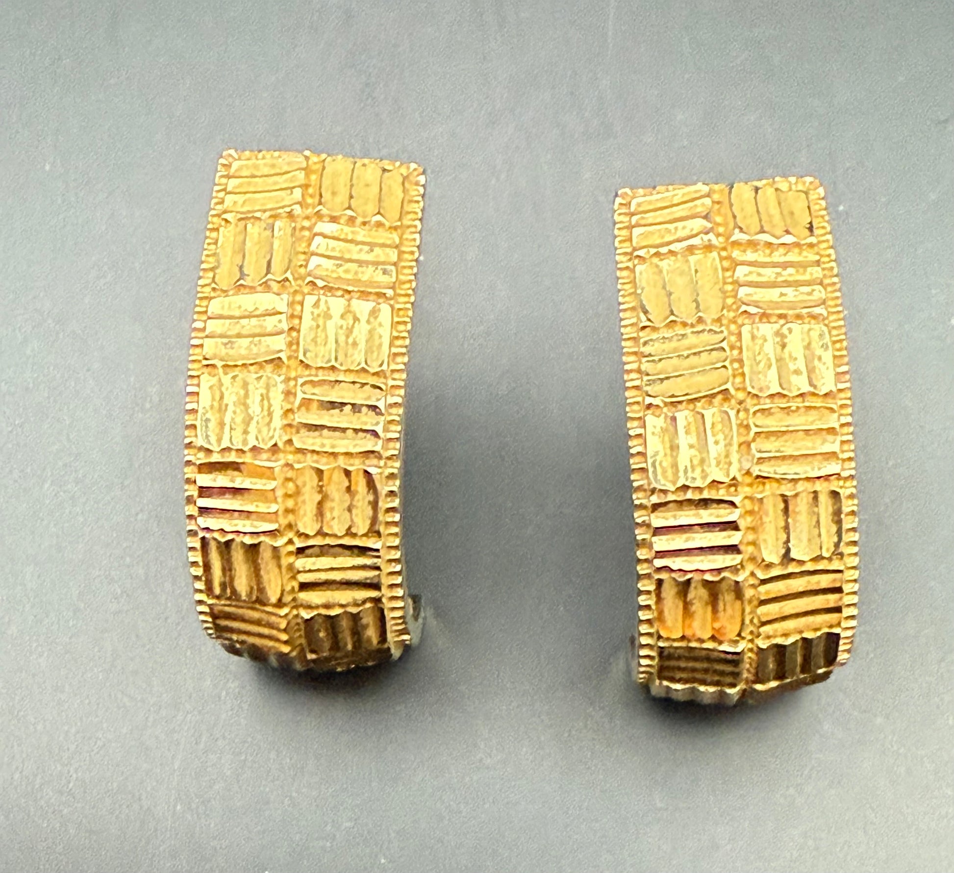 Close-up of vintage ZRW 14k gold textured half hoop earrings showing geometric diamond cut pattern