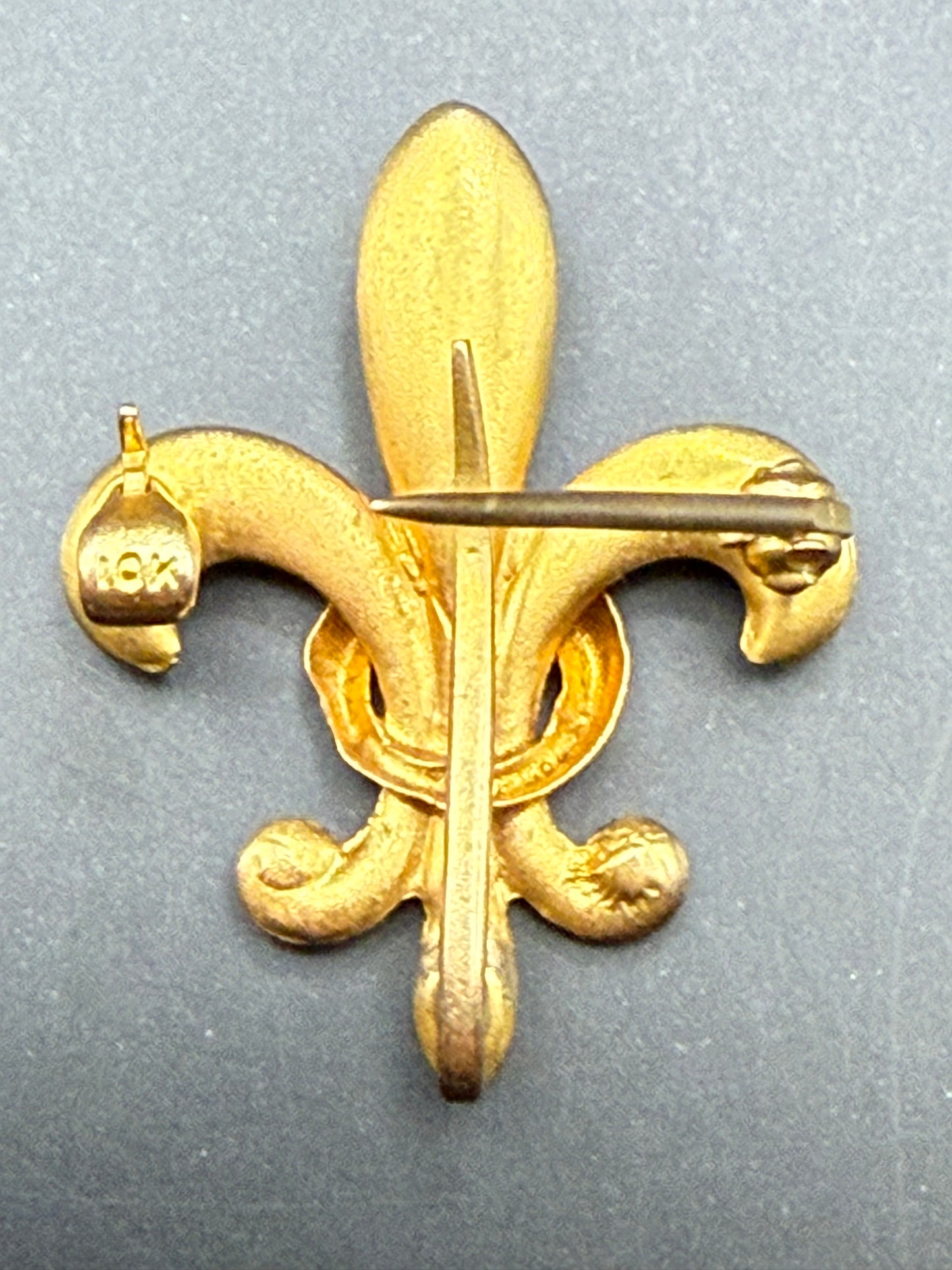 Reverse view of Fleur-de-Lis pin showing 10K stamp and back loop for pendant