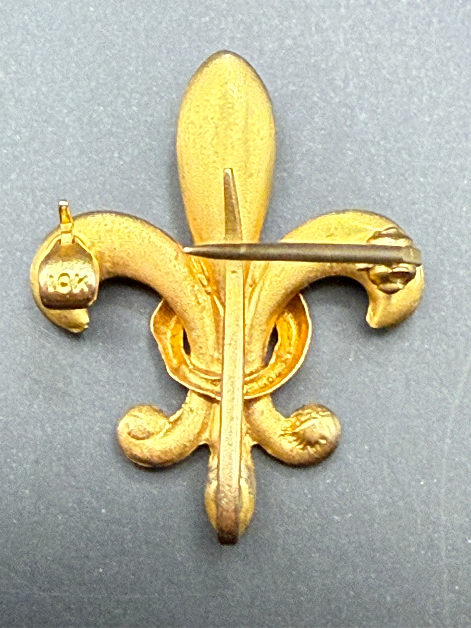 Reverse view of Fleur-de-Lis pin showing 10K stamp and back loop for pendant