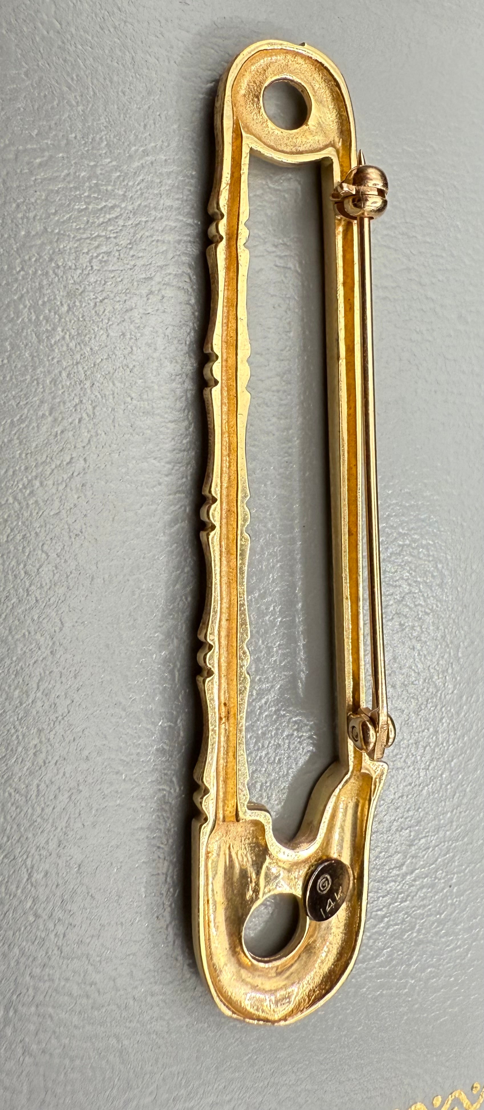 Reverse view of gold safety pin showing pin clasp and 14K stamp