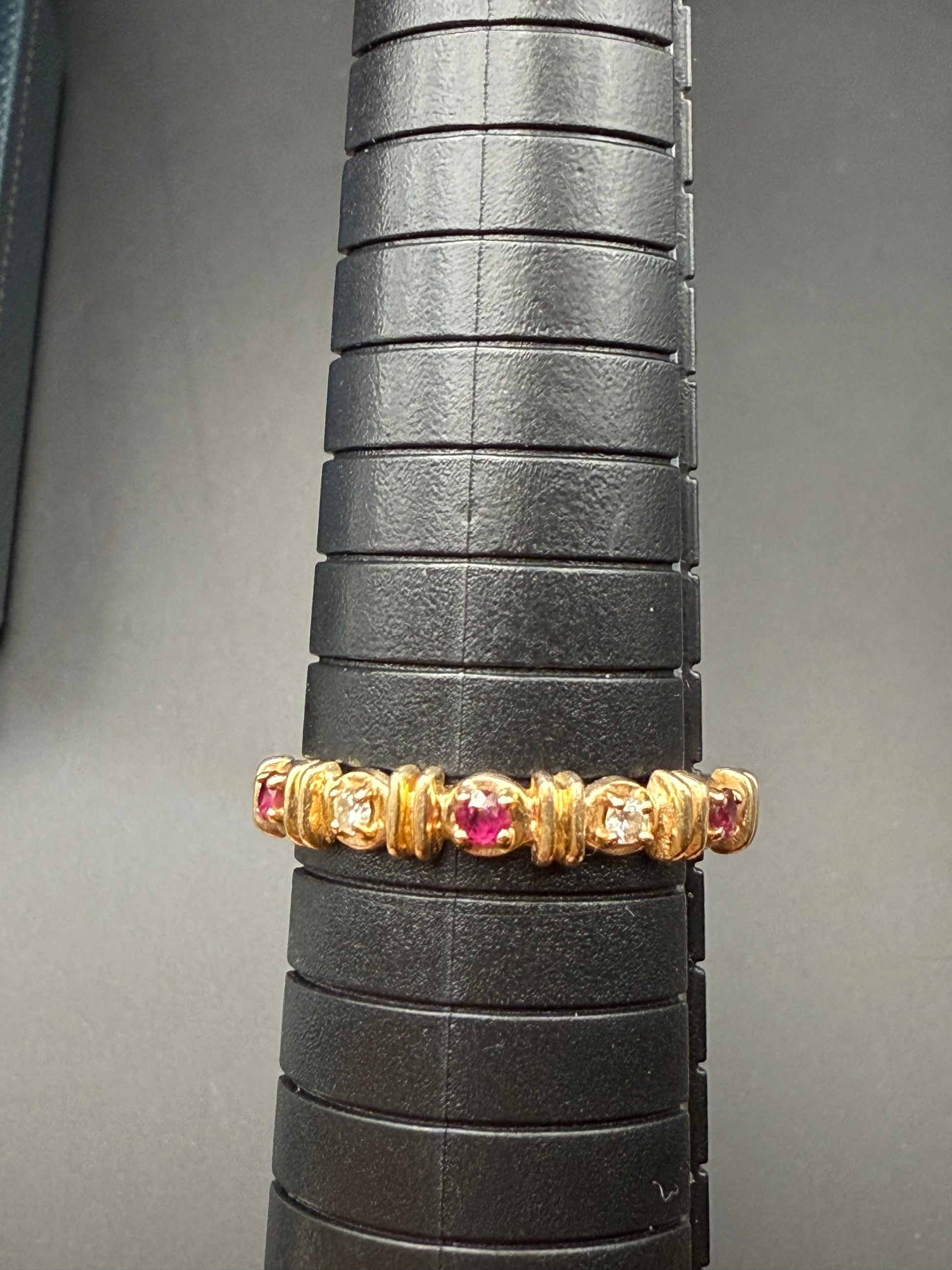 Ring on mandrel showing approximate size 7 and alternating rubydiamond-style design