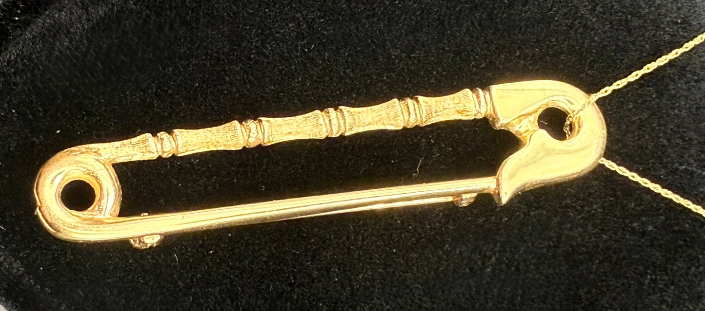 Safety pin pendant displayed on chain, showing versatility as pendant