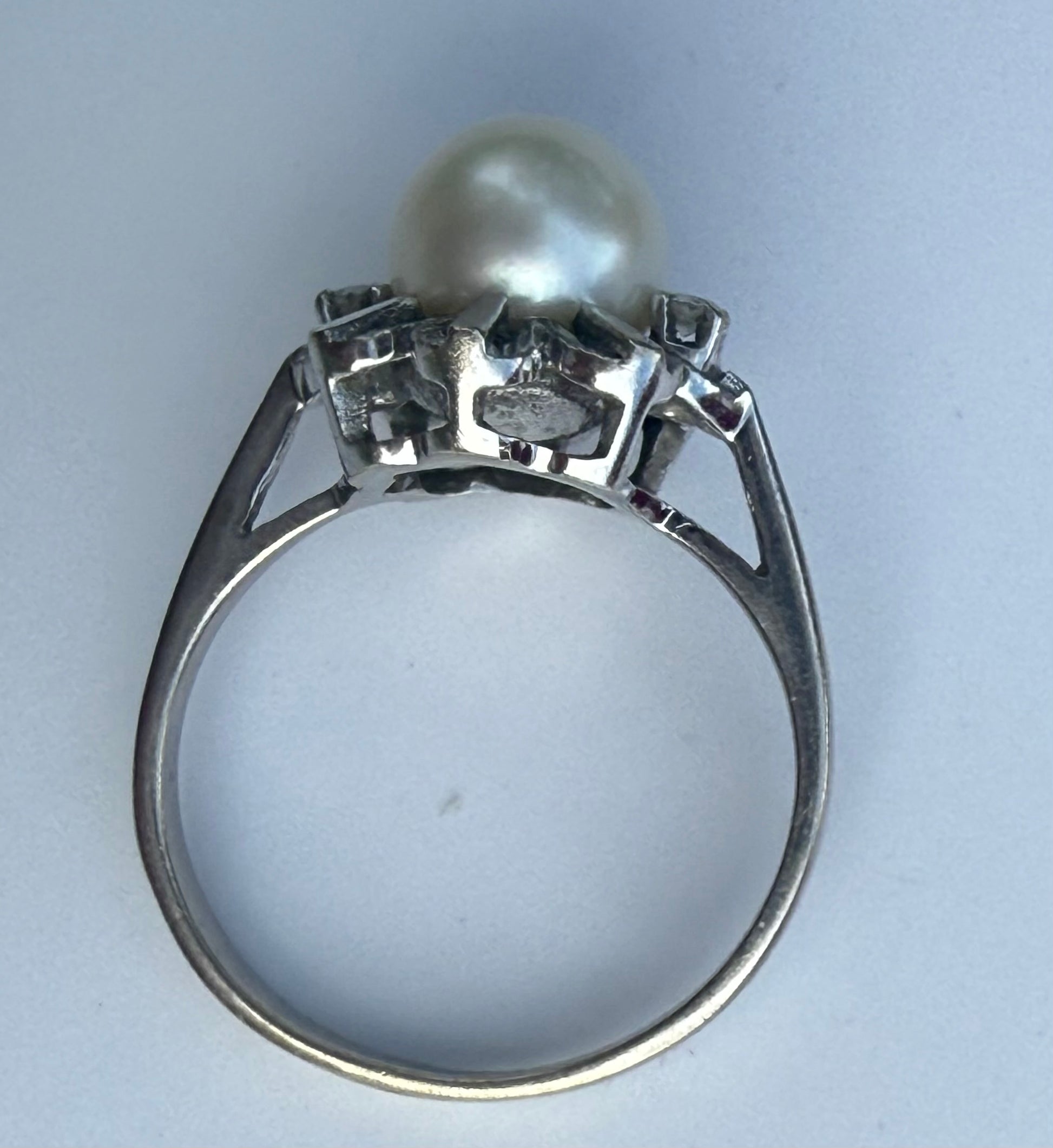 Side profile of pearl and diamond vintage ring in white gold.