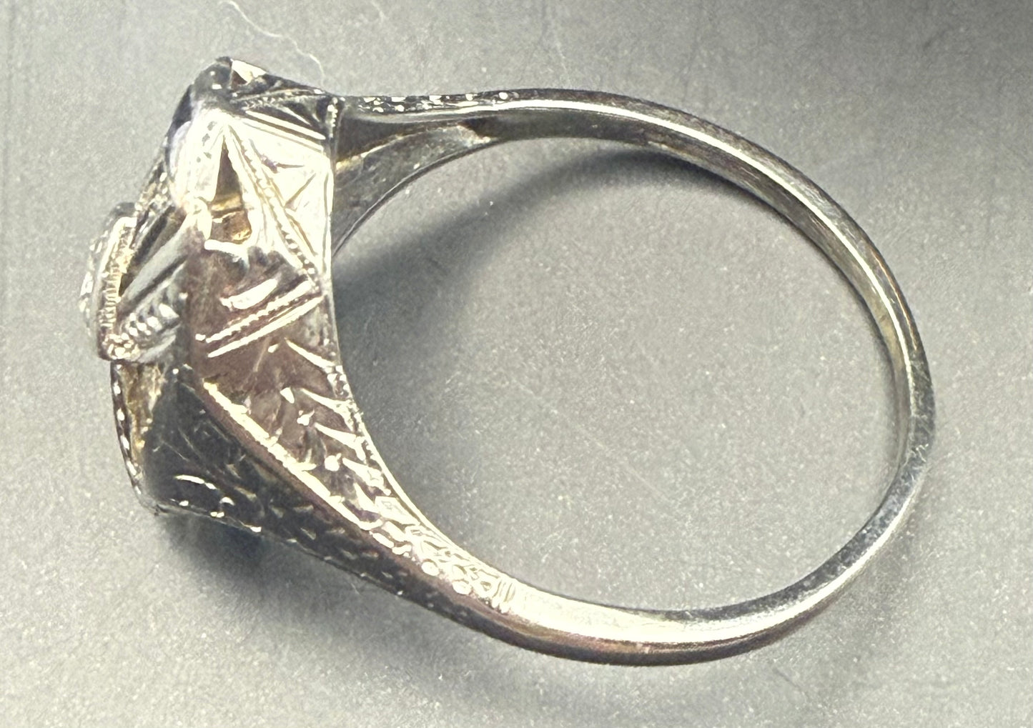 Side profile of vintage filigree ring showing engraved shank and openwork design