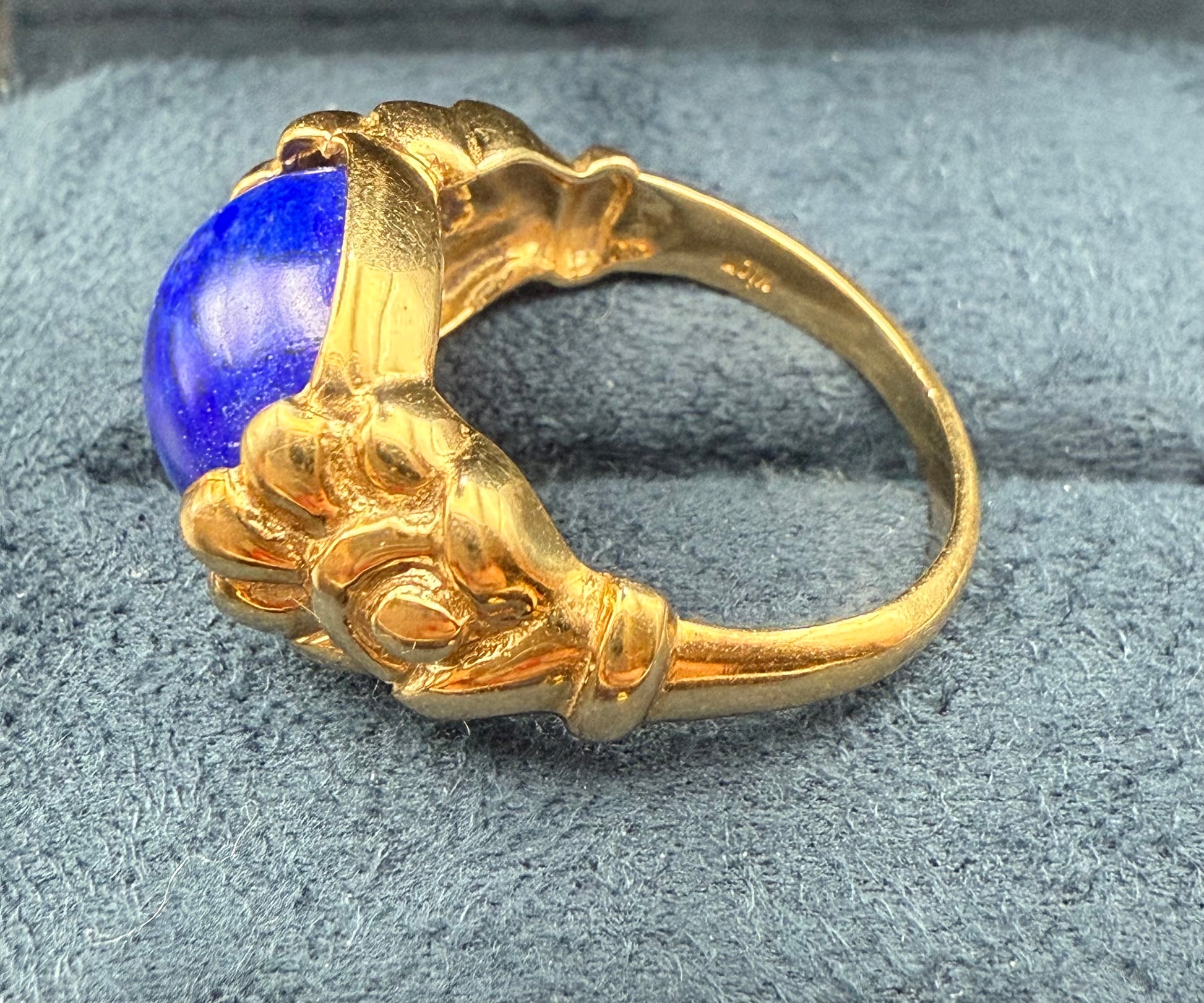Side view of antique 10K gold lapis ring showing sculpted floral and leaf motif.