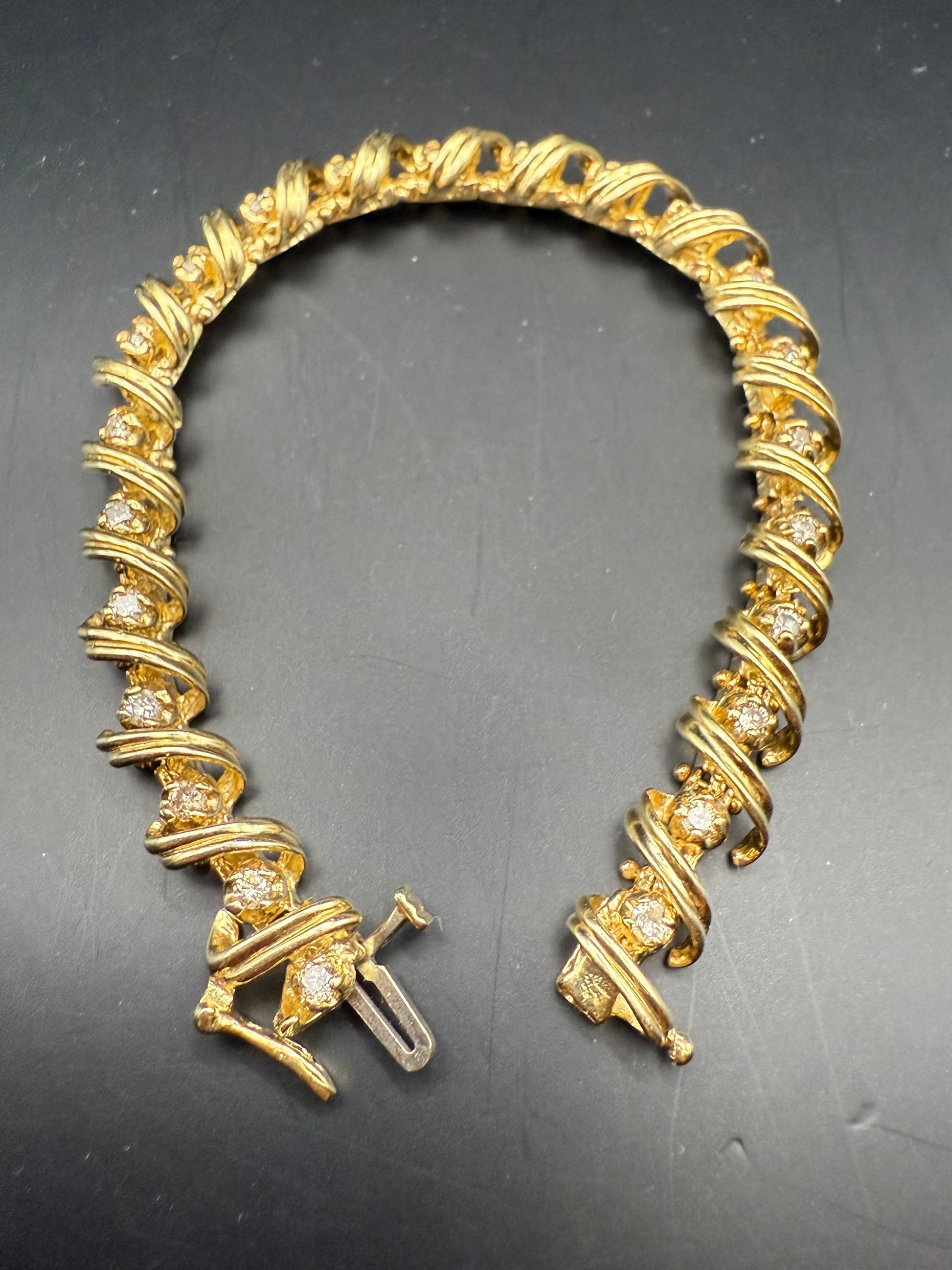 Side view showing diamonds set within curved gold scroll links and box clasp