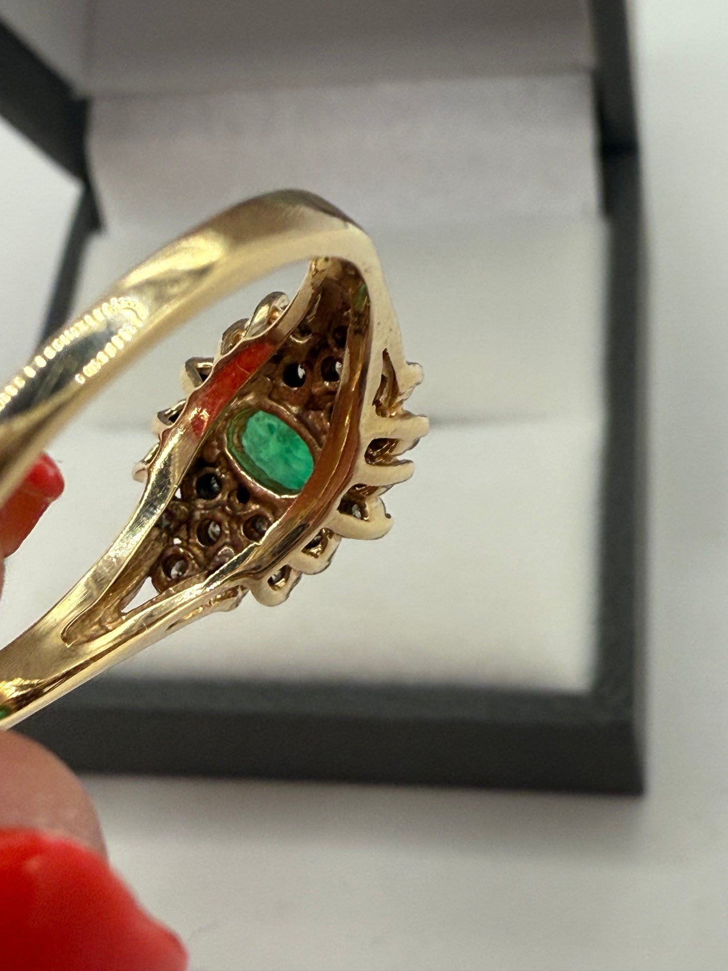 Underside view of emerald cluster ring showing gemstone setting