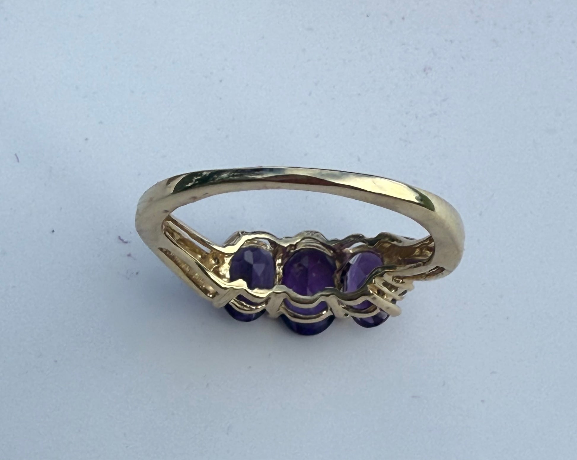 Back View of Vintage 3-stone amethyst ring in yellow gold with oval purple gemstones, trilogy design symbolizing past, present, and future.